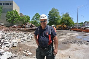William Graffen of the Malden Fire Department maintains safe dust levels on the first day of demolition of the Ruderman's Building.